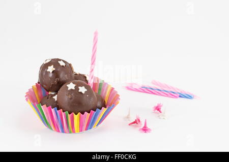 Le sfere di cioccolato e candele su sfondo bianco Foto Stock