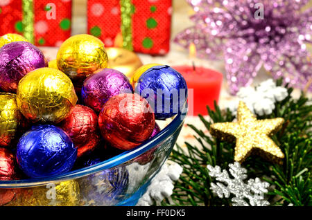 Ciotola con il cioccolato colorato e decorazione di Natale sul tavolo Foto Stock