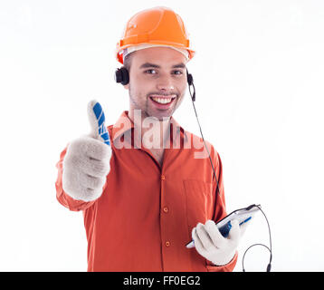 Un builder con telefono e dando un pollice in alto. Foto Stock