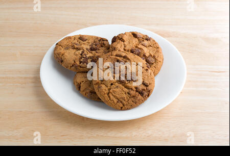 Una piastra di latte i biscotti al cioccolato su una tavola di legno top illuminato con luce naturale. Foto Stock