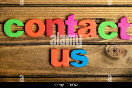Colorato Contattaci parola sul tavolo di legno Foto Stock