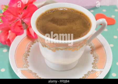 Vintage tazza di caffè su un tavolo decorato con fiori Foto Stock