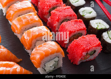 Set di sushi e rotola su una tavola di ardesia. Foto Stock