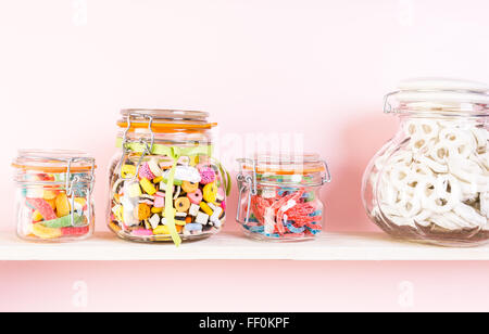 Caramelle colorate in vasi sul ripiano. Foto Stock