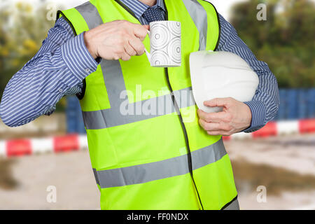 Geometra in hi vis con cappello rigido avente una pausa caffè su un sito di costruzione Foto Stock