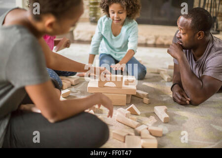 La famiglia gioca con la costruzione di blocchi in salotto Foto Stock