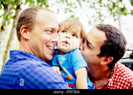 I padri Gay kissing baby figlio all'aperto Foto Stock