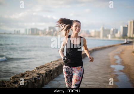 Razza mista amputato atleta jogging sul lungomare urbano Foto Stock