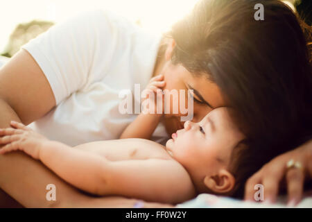 Razza mista madre nuzzling baby Foto Stock