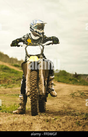 Uomo caucasico equitazione dirt bike nel campo Foto Stock