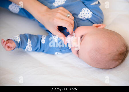 Madre caucasica dando la nostra bambina succhietto Foto Stock
