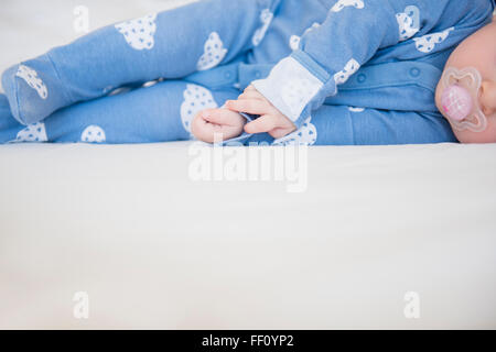 Caucasian Baby girl posa sul letto Foto Stock
