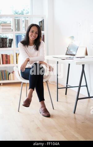 Razza mista imprenditrice sorridente in ufficio in casa Foto Stock