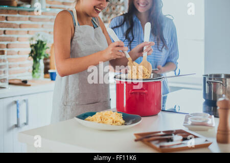 Le donne del Caucaso la cottura della pasta in cucina Foto Stock