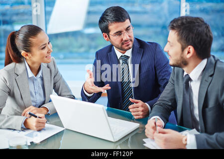 Happy businessman spiegando collega i punti principali del nuovo progetto Foto Stock