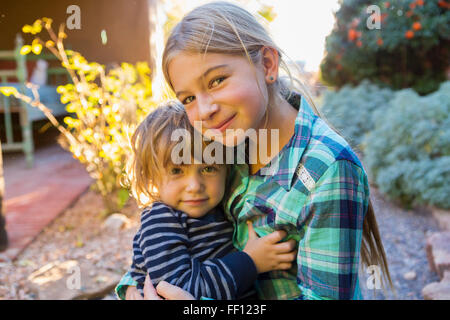 Caucasian fratello e sorella replicando all'aperto Foto Stock