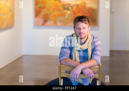 Uomo caucasico seduti in galleria d'arte Foto Stock