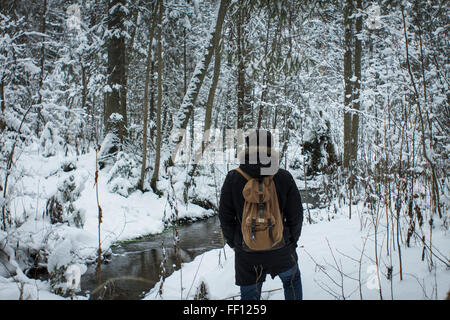 Escursionista caucasica passeggiate nel bosco innevato Foto Stock