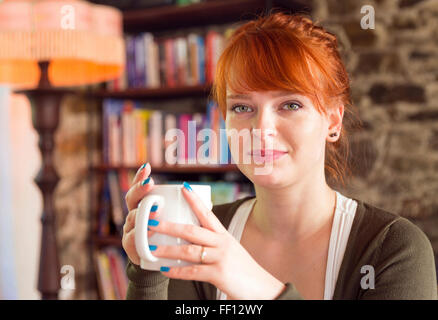 La donna caucasica di bere il caffè Foto Stock