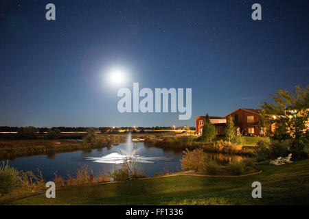 Il sorgere del sole sulla fontana nel paesaggio rurale Foto Stock