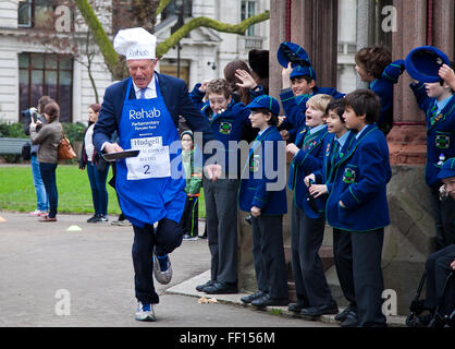 Westminster, Londra, Regno Unito. 9 febbraio 2016 - Lord St John di Bletso scorre a pancake parlamentare gara in aiuto della disabilità carità, Rehab mentre un gruppo di bambini della scuola di guardare alla gara Credito: Dinendra Haria/Alamy Live News Foto Stock