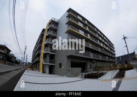 Nuovo alloggiamento pubblico nel quartiere Nango di Kesennuma City il 9 febbraio 2016, Prefettura di Miyagi, Giappone. Kesennuma City è stato uno dei peggiori luoghi colpiti dallo tsunami e dal terremoto del mese di marzo 2011 con molti edifici distrutti e oltre mille residenti di perdere la loro vita. Questo blocco 3 Nango Residence è stato completato nel 2015 ed ora alloggia permanentemente alcune 150 famiglie. Lo sviluppo è costruito su un pezzo di terra che ha usato essere una scuola ma fu distrutto dal terremoto e dallo tsunami. Ci sono certamente segni positivi di ricostruzione in zona ma alcuni 2.000 fuori di 2. 351 prefabbricato case temporanee in Kesennuma City sarà rem Foto Stock