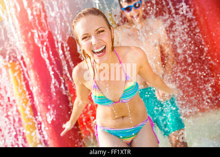 Matura in tute swimmning sotto gli spruzzi di una fontana. Il calore d'estate. Foto Stock