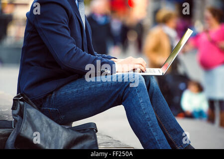 Irriconoscibile manager che lavora sul computer portatile sul affollato Piccadilly C Foto Stock