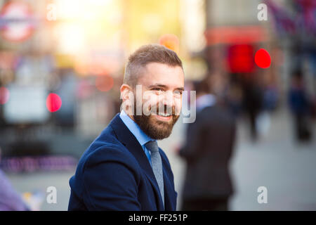 Hipster manager nella strada affollata di Londra, Piccadilly Circus Foto Stock
