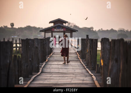 Monaco buddista su U Bein ponte in teak a sunrise, MandaRMay, Regione MandaRMay, Myanmar (Birmania), Asia Foto Stock