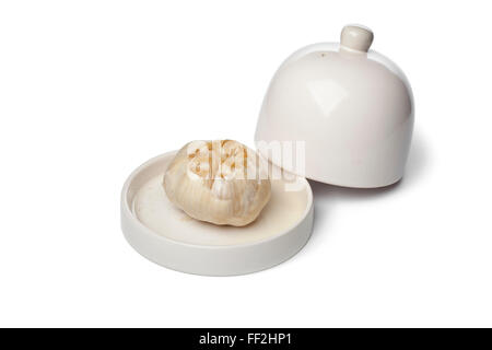 Aglio Arrostito lampadina in un piatto su sfondo bianco Foto Stock