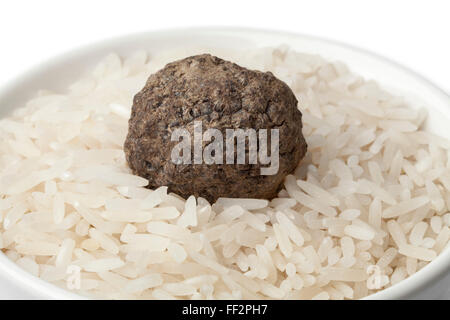 Tazza di riso crudo fresco con tartufo nero pregiato tartufo close up su sfondo bianco Foto Stock