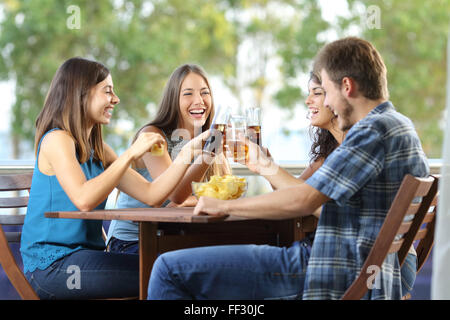 Un gruppo di 4 amici felice tostare in un albergo o casa terrazza Foto Stock