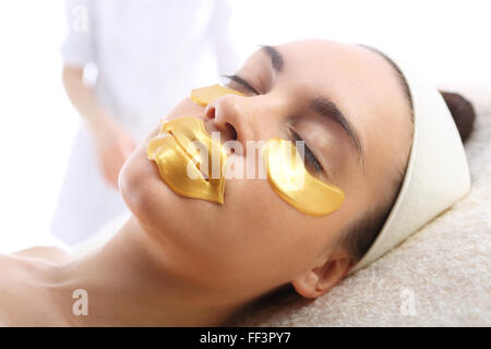 Procedura di personalizzazione, il volto di donna con scaglie d'oro sotto gli occhi e sulle labbra Foto Stock