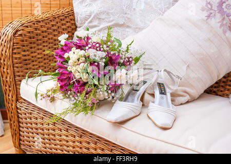 Fiore e scarpe nuziale sul divano per ottenere pronto Foto Stock
