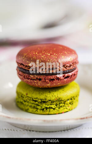 Matcha e Rosa Macaron con la formazione di polvere di oro su un piatto da caffè Foto Stock