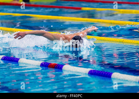 Atleta nuotatore nuoto nella piscina butterfly. vista laterale Foto Stock