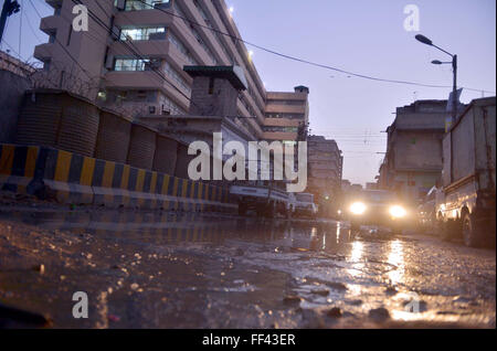 Pendolari passano attraverso il ristagno di acqua di fognatura creando problemi per pendolari e mostra la negligenza delle autorità interessate, dietro il gruppo del Sindh edificio a Kamal Ataturk Road a Karachi il mercoledì 10 febbraio, 2016. Foto Stock