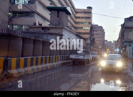 Pendolari passano attraverso il ristagno di acqua di fognatura creando problemi per pendolari e mostra la negligenza delle autorità interessate, dietro il gruppo del Sindh edificio a Kamal Ataturk Road a Karachi il mercoledì 10 febbraio, 2016. Foto Stock