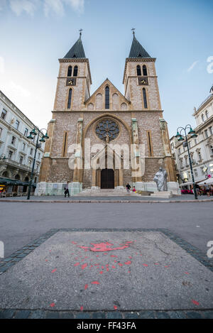 Guscio di malta di cemento della cicatrice dell assedio di Sarajevo perdiod riempito con resina rossa (Sarajevo Rose) nella parte anteriore della cattedrale di Sarajevo Foto Stock