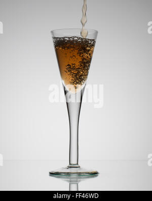 Vetro con un drink colata e schizzi Foto Stock