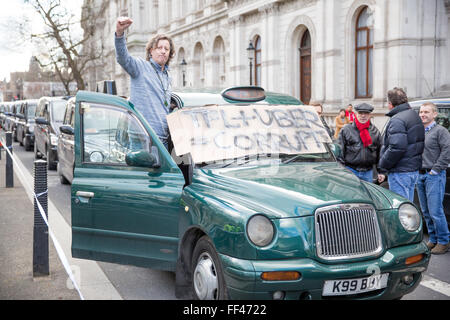 Londra, Regno Unito. Il 10 febbraio 2016. Un 'black cab " taxi driver con un preavviso criticando TFL e Uber durante un go-slow protesta a Whitehall contro la mancanza di controllo da parte del governo di app minicab Uber. i tassisti di tenere un go-slow protesta a Whitehall in segno di protesta contro la mancanza di controllo da parte del governo di minicab Uber app. Credito: Mark Kerrison/Alamy Live News Foto Stock