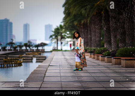 Donna e bambino di Xiamen, Cina, passeggiate sulla baia parco divertimenti per il lungomare. Foto Stock