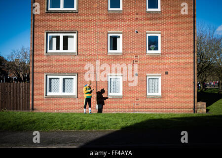 Ashbourne,Derbyshire,UK,10 Febbraio 2016.Il giorno 2 del Royal Ashbourne shrovetide football " mercoledì delle ceneri' ,giocare iniziato alle 14.00 da shawcroft parcheggio e può continuare fino alle 22,00 quando se nessun gol segnati il gioco finisce. Shrovetide giocatore trova un posto tranquillo per controllare il suo telefono cellulare. Foto Stock