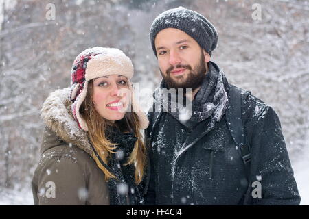 Barbuto ragazzo e ragazza brunetet in posa nella neve Foto Stock