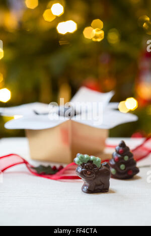 Novità di Natale fatti a mano i cioccolatini, compresa una renna contro lo sfondo di albero di Natale luci. Foto Stock