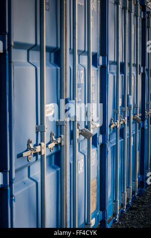 Una fila di blu Self Storage i contenitori di spedizione in un composto protetto Foto Stock