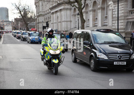 Londra, Regno Unito. Il 10 febbraio 2016. Una polizia motociclista assicura che black cab taxi driver Keep moving in Whitehall durante le prime fasi di go-slow protesta. Credito: Mark Kerrison/Alamy Live News Foto Stock