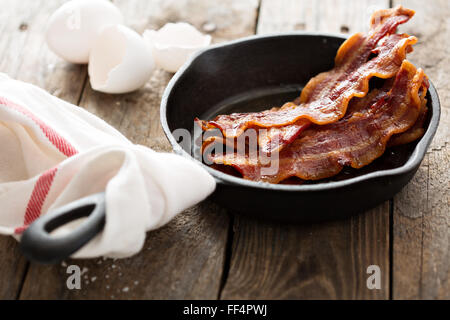 Sizzling hot bacon in una padella in ghisa Foto Stock