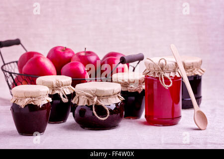 Conserve di frutta fatte in casa e marmellate ai frutti di bosco nel vaso del frullatore. Stile rustico. Foto Stock